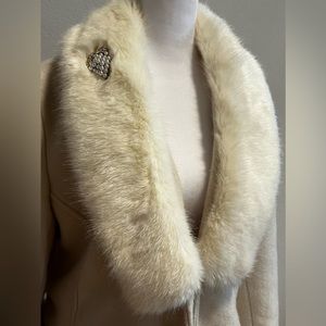Furry women white coat with brooch.